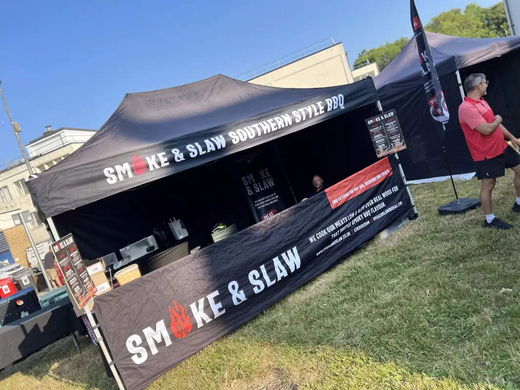 Branded Smoke & Slaw gazebo on the grass at an outdoor festival