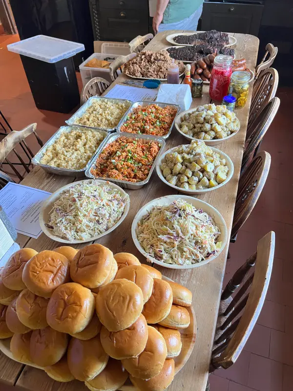 Buns, slaw, potato salad and trays of food on a wedding table